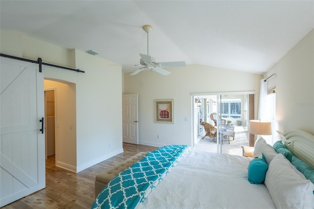 1046 Ridgeland Path, The Villages, FL 32162 - bedroom with a barn door, wood finished floors, lofted ceiling, baseboards, and visible vents