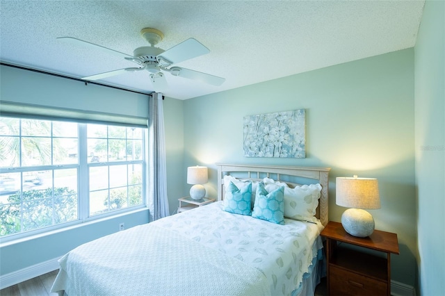 1046 Ridgeland Path, The Villages, FL 32162 - bedroom with baseboards, a textured ceiling, and a ceiling fan