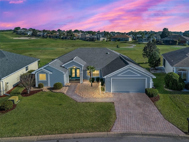 11743 SE 174th Loop, Summerfield, FL 34491 - ranch-style home featuring an attached garage, decorative driveway, a residential view, stucco siding, and a yard