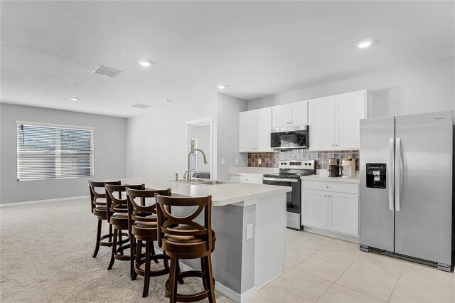 2636 Neverland Dr, New Smyrna Beach, FL 32168 - kitchen with an island with sink, a sink, stainless steel appliances, light countertops, and tasteful backsplash