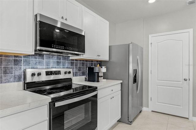 2636 Neverland Dr, New Smyrna Beach, FL 32168 - kitchen with backsplash, appliances with stainless steel finishes, white cabinets, and light countertops