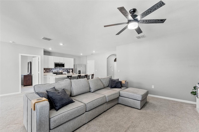 2636 Neverland Dr, New Smyrna Beach, FL 32168 - living room featuring ceiling fan, arched walkways, visible vents, and light carpet