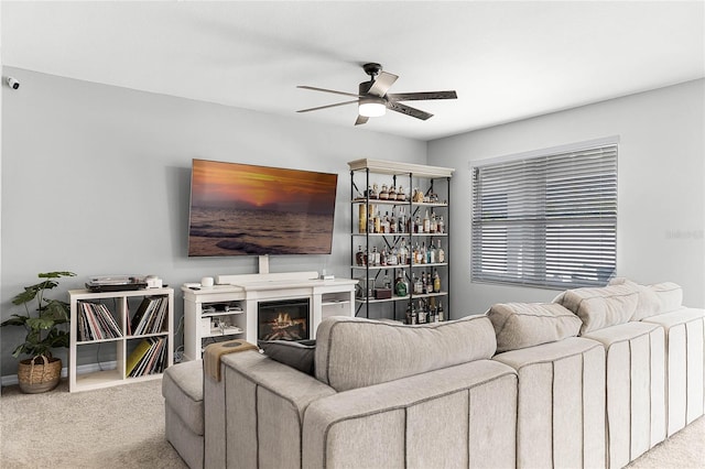 2636 Neverland Dr, New Smyrna Beach, FL 32168 - carpeted living area featuring a glass covered fireplace and ceiling fan