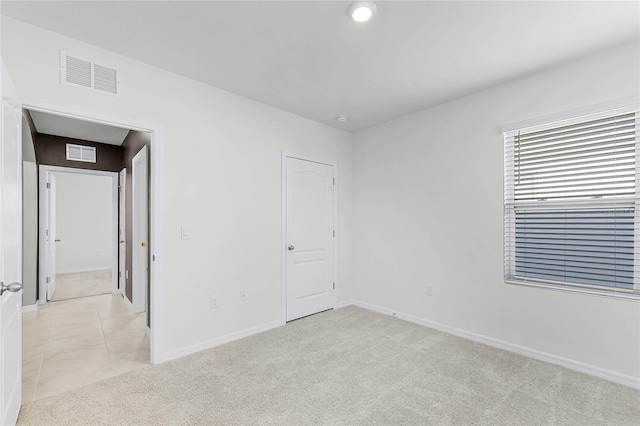 2636 Neverland Dr, New Smyrna Beach, FL 32168 - unfurnished room with light tile patterned floors, visible vents, baseboards, and light colored carpet