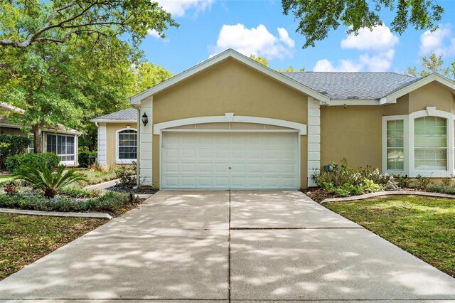 6152 Topsail Rd, Lady Lake, FL 32159 - single story home with a shingled roof, driveway, stucco siding, and an attached garage