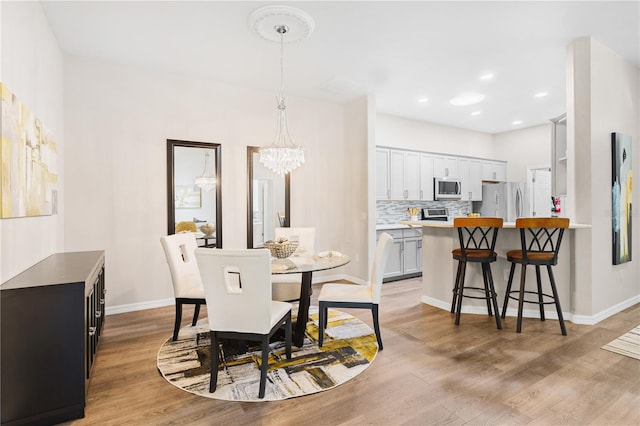 6152 Topsail Rd, Lady Lake, FL 32159 - dining space featuring light wood finished floors, baseboards, recessed lighting, and a chandelier