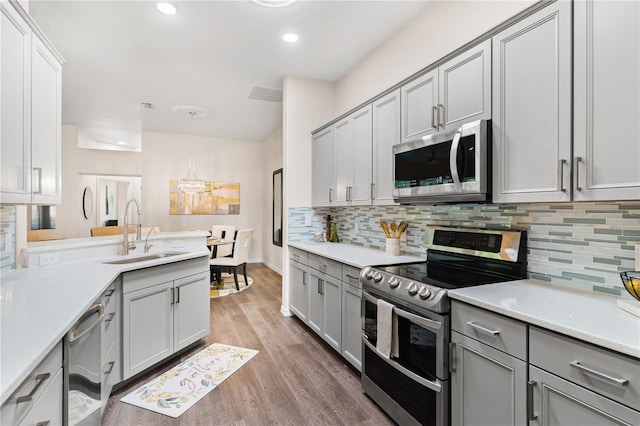 6152 Topsail Rd, Lady Lake, FL 32159 - kitchen with gray cabinets, a sink, and stainless steel appliances
