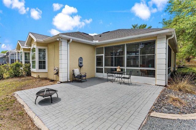 6152 Topsail Rd, Lady Lake, FL 32159 - rear view of house featuring a sunroom, stucco siding, a patio, a fire pit, and a shingled roof
