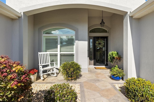 view of exterior entry with stucco siding