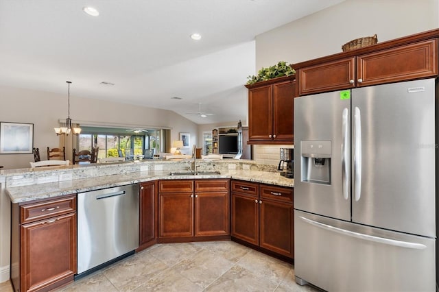 kitchen with a sink, vaulted ceiling, light stone countertops, and stainless steel appliances