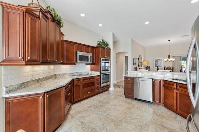 kitchen featuring light stone counters, arched walkways, stainless steel appliances, backsplash, and a chandelier