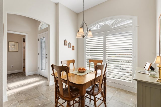dining room featuring baseboards and arched walkways