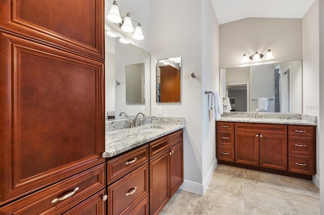 full bathroom featuring lofted ceiling, two vanities, and a sink