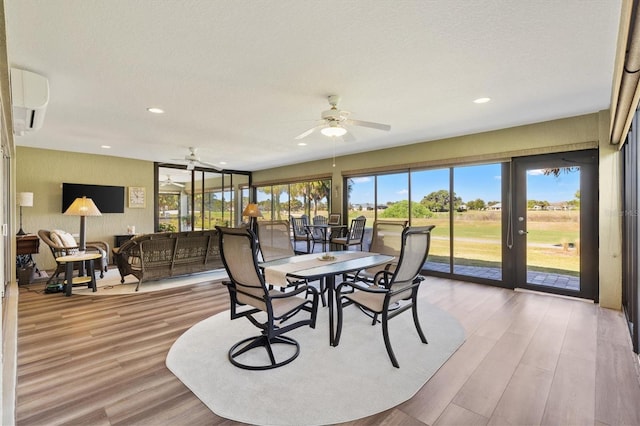 sunroom with french doors, an AC wall unit, and ceiling fan