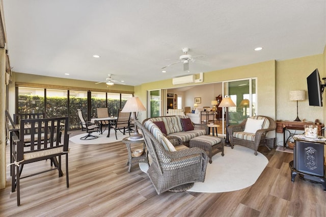 living area with recessed lighting, a wall mounted air conditioner, a ceiling fan, and wood finished floors