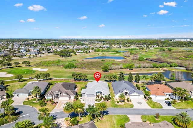 drone / aerial view with a residential view, view of golf course, and a water view