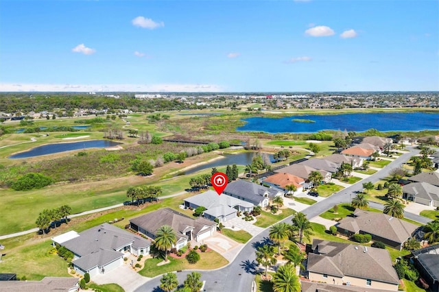 drone / aerial view with a residential view, a water view, and golf course view