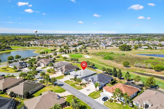 drone / aerial view with a residential view, golf course view, and a water view