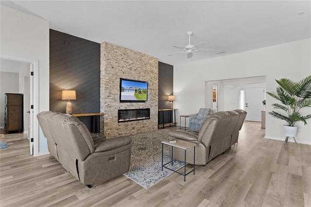 6444 Mcknight Loop, The Villages, FL 34762 - living area featuring light wood-style floors, a ceiling fan, a fireplace, baseboards, and wooden walls