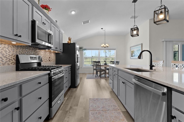 6444 Mcknight Loop, The Villages, FL 34762 - kitchen featuring appliances with stainless steel finishes, a sink, lofted ceiling, light wood-style floors, and gray cabinetry