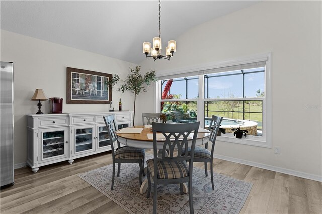 6444 Mcknight Loop, The Villages, FL 34762 - dining space with vaulted ceiling, a chandelier, light wood-style floors, and baseboards