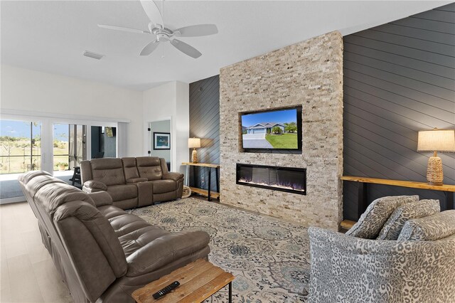 6444 Mcknight Loop, The Villages, FL 34762 - living area featuring a large fireplace, a ceiling fan, and wooden walls