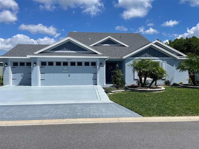 6444 Mcknight Loop, The Villages, FL 34762 - ranch-style house featuring a garage, a front yard, roof with shingles, driveway, and board and batten siding