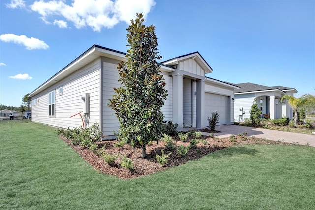 view of property exterior with a yard, a garage, and driveway