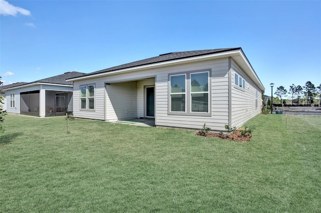 rear view of property with a yard and a sunroom