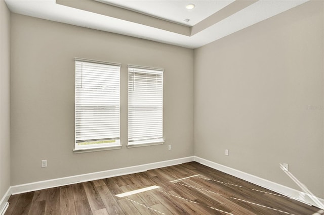 spare room featuring baseboards and dark wood-type flooring