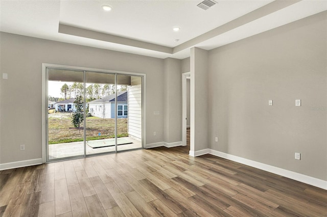unfurnished room with visible vents, baseboards, and wood finished floors
