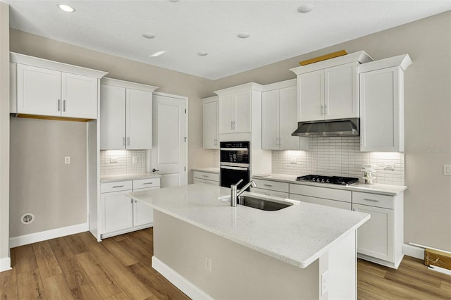 kitchen with under cabinet range hood, white cabinetry, black gas cooktop, and a sink