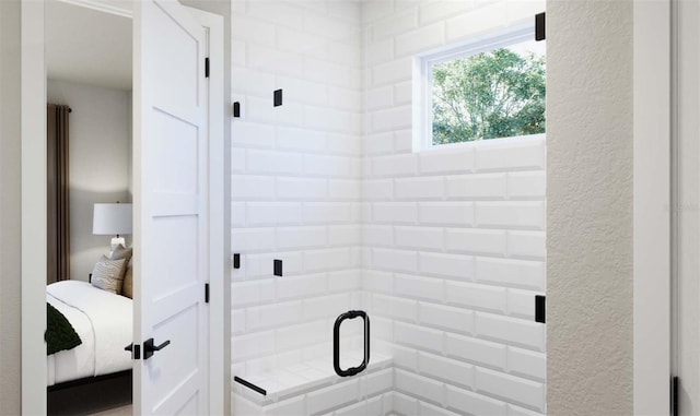 bathroom featuring a shower stall and a textured wall
