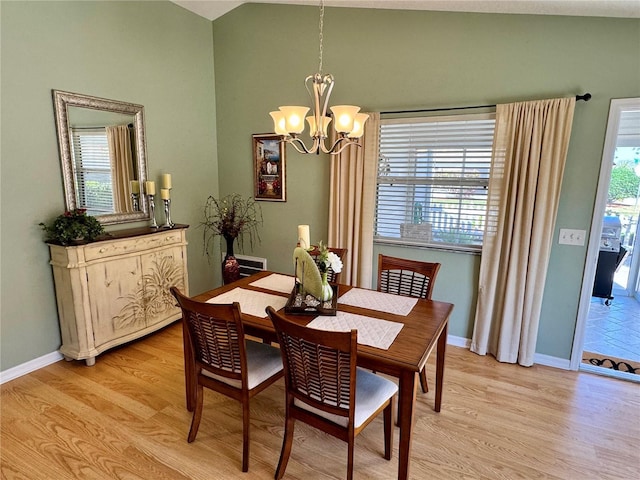 dining area with a chandelier, light wood-type flooring, and baseboards