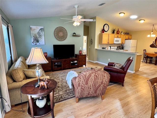 living room featuring visible vents, baseboards, lofted ceiling, light wood-style flooring, and a ceiling fan
