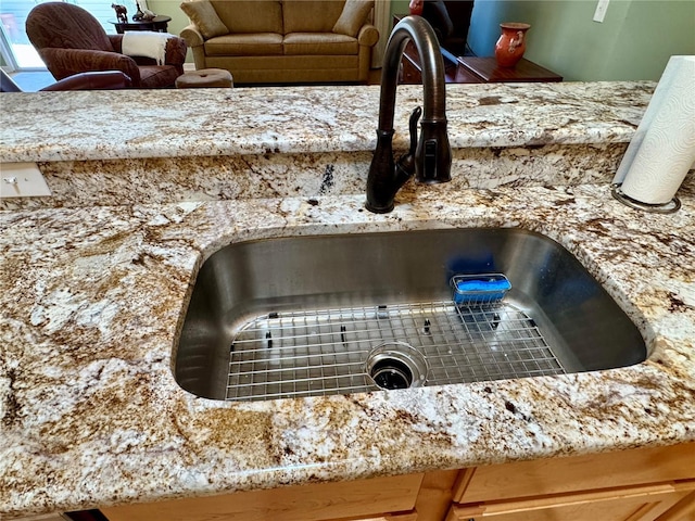 details featuring light stone counters and a sink