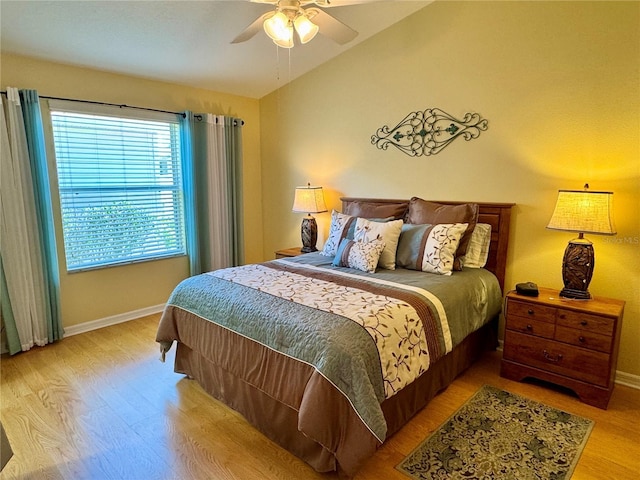 bedroom featuring baseboards, lofted ceiling, a ceiling fan, and light wood finished floors