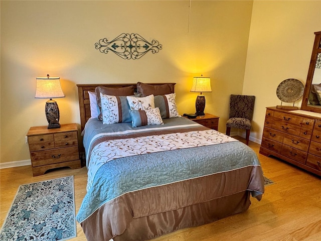 bedroom with baseboards and wood finished floors