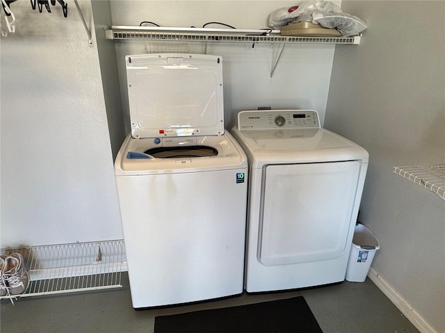 clothes washing area featuring baseboards, independent washer and dryer, and laundry area