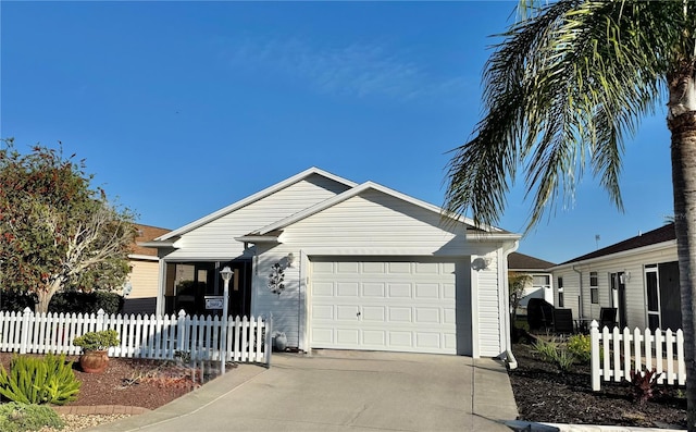 view of front facade with concrete driveway, fence, and a garage