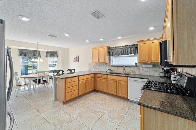 1417 Forest Acres Dr, The Villages, FL 32162 - kitchen with visible vents, a peninsula, a sink, appliances with stainless steel finishes, and backsplash