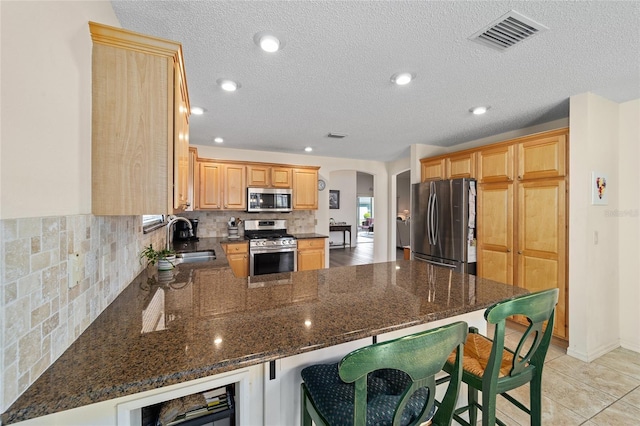 1417 Forest Acres Dr, The Villages, FL 32162 - kitchen with visible vents, appliances with stainless steel finishes, a peninsula, arched walkways, and a sink