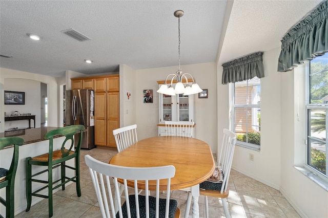1417 Forest Acres Dr, The Villages, FL 32162 - dining area featuring a textured ceiling, a healthy amount of sunlight, visible vents, and a chandelier