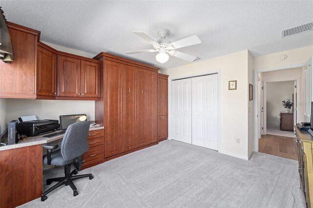 1417 Forest Acres Dr, The Villages, FL 32162 - office featuring visible vents, light carpet, a textured ceiling, built in desk, and ceiling fan