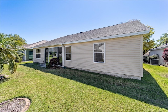1417 Forest Acres Dr, The Villages, FL 32162 - back of house featuring central air condition unit, a lawn, and a shingled roof