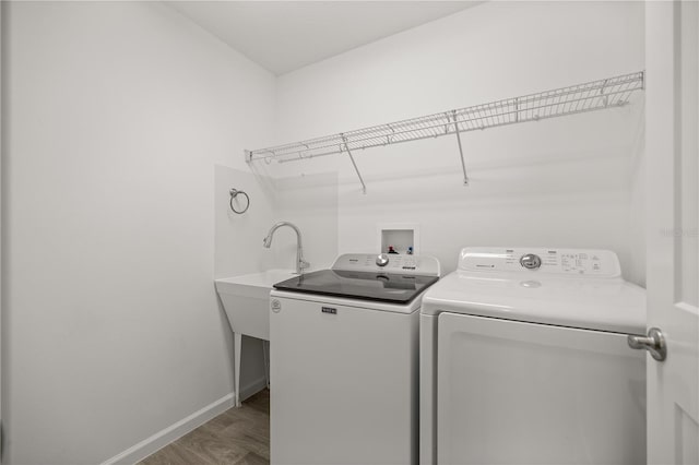 1853 Pasqua Pl, The Villages, FL 32163 - washroom with baseboards, laundry area, washer and dryer, a sink, and wood finished floors