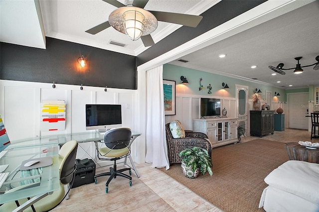 interior space with wainscoting, ornamental molding, a ceiling fan, and a decorative wall