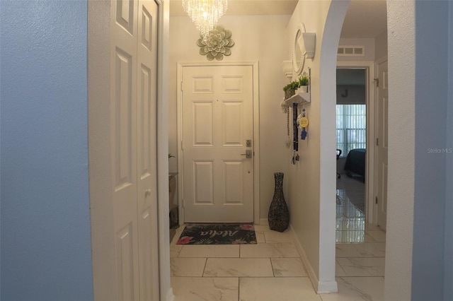 2442 Foxhollow Rd, Tavares, FL 32778 - interior space with baseboards, a chandelier, marble finish floor, arched walkways, and visible vents