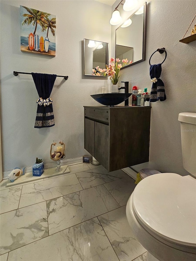2442 Foxhollow Rd, Tavares, FL 32778 - bathroom with baseboards, marble finish floor, toilet, and vanity