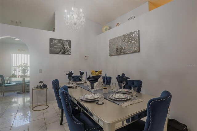 2442 Foxhollow Rd, Tavares, FL 32778 - dining room with visible vents, marble finish floor, arched walkways, a high ceiling, and an inviting chandelier